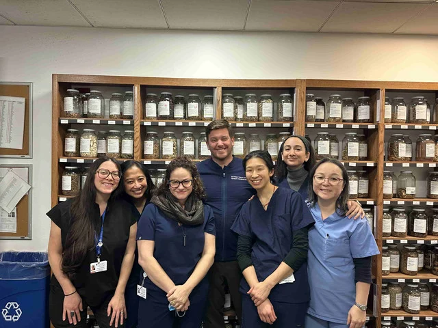 Dr. Peter Caron with a group of acupuncture students in front of an herbal dispensary